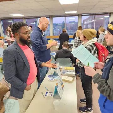 two students talk to two professors