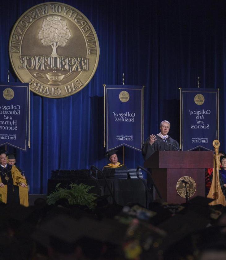 male alumni awardee giving the "Charge to the Class" address in ceremony